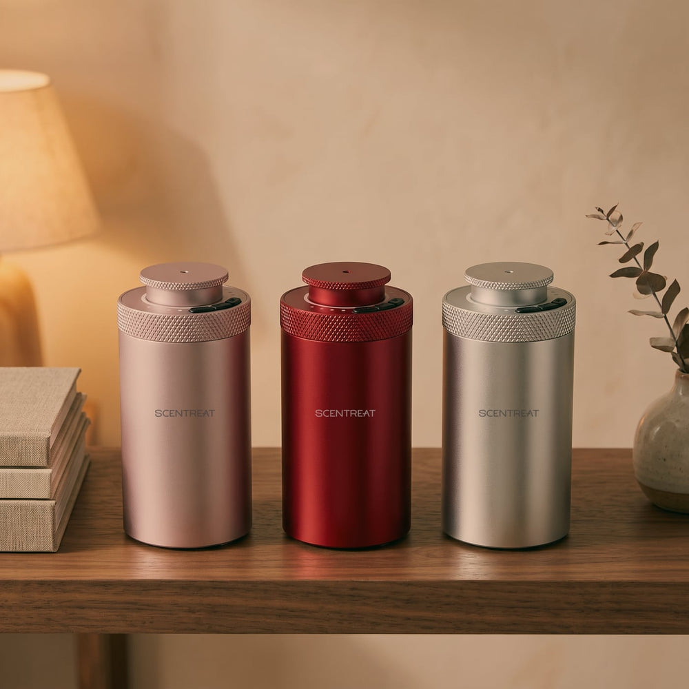 Roam mini waterless diffusers in pink, red and silver on a walnut shelf
