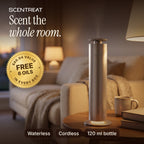 Silver cordless aluminum tower diffuser on a walnut side table in a warm living room