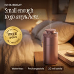 Pink mini aluminum waterless diffuser on a walnut nightstand