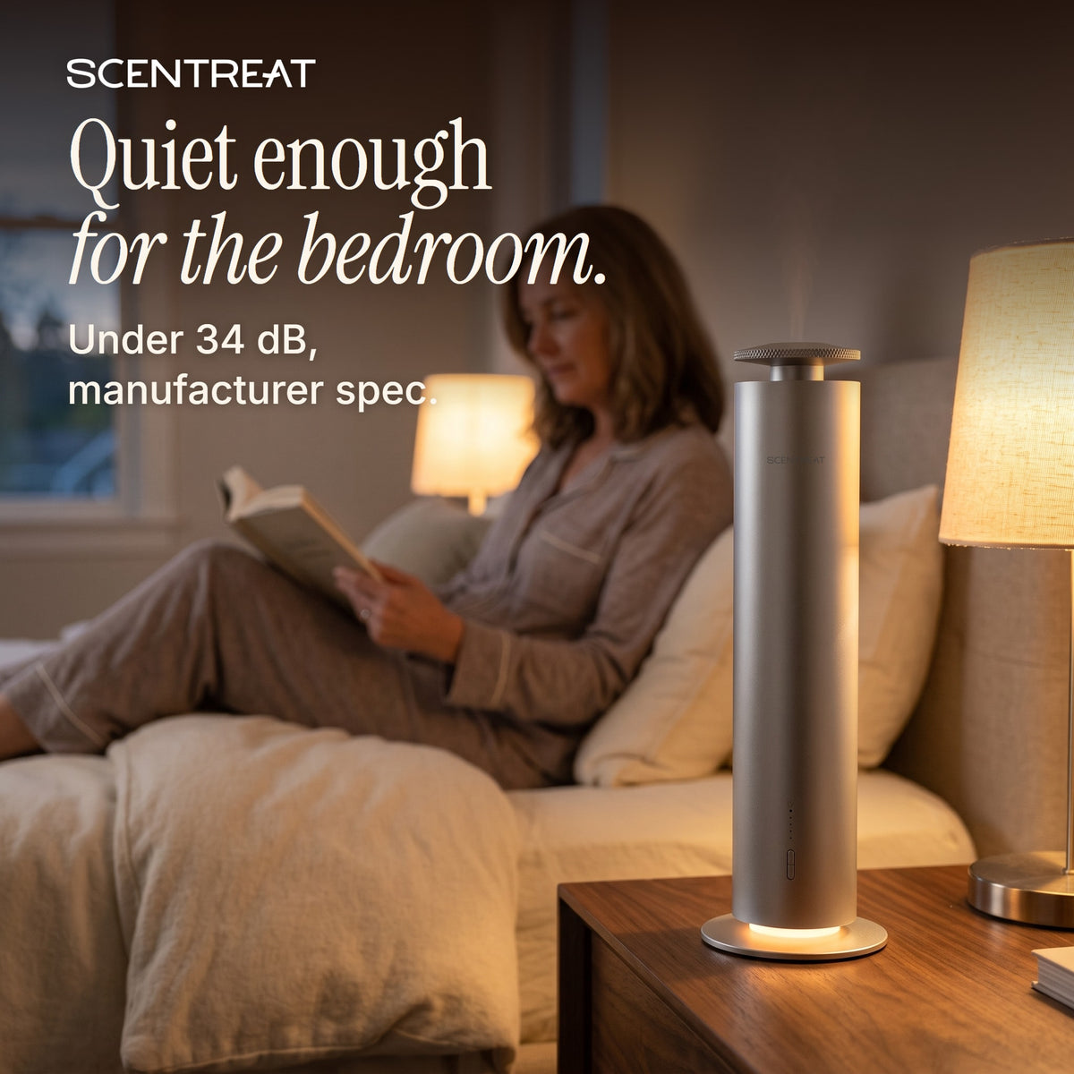 Woman reading in bed beside the quiet tower diffuser
