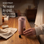 Hand holding a 20 ml essential oil bottle next to the mini diffuser