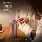 Finger pressing a button on top of the mini diffuser